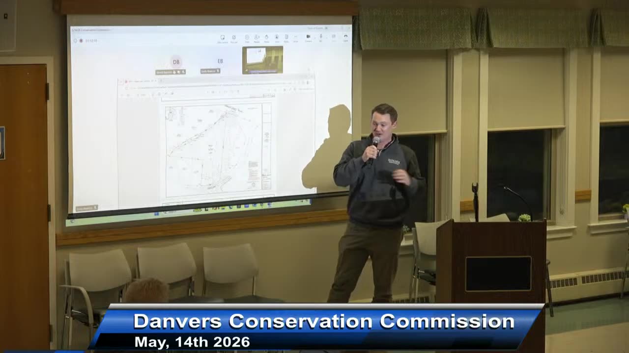 Site plan projection with presenter at podium