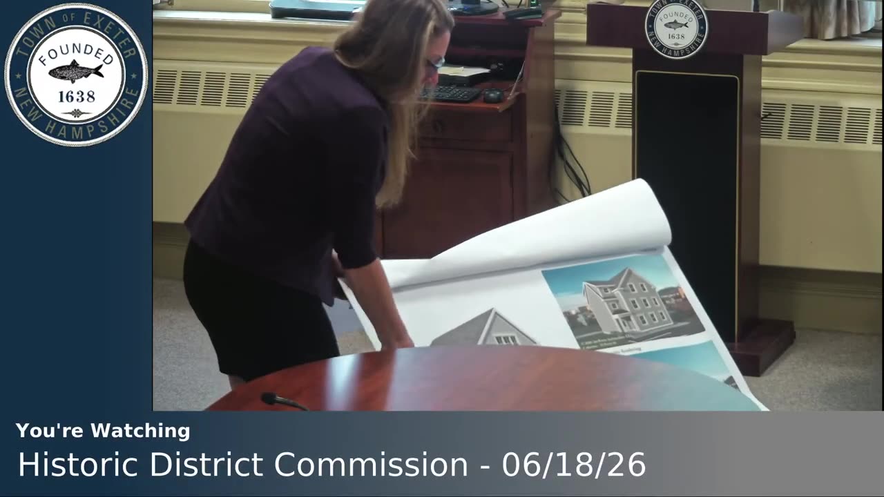 Large format architectural renderings and elevations unrolled on table
